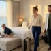 Family relaxing inside a spacious modern hotel suite with large beds and a beautiful window view during a family vacation